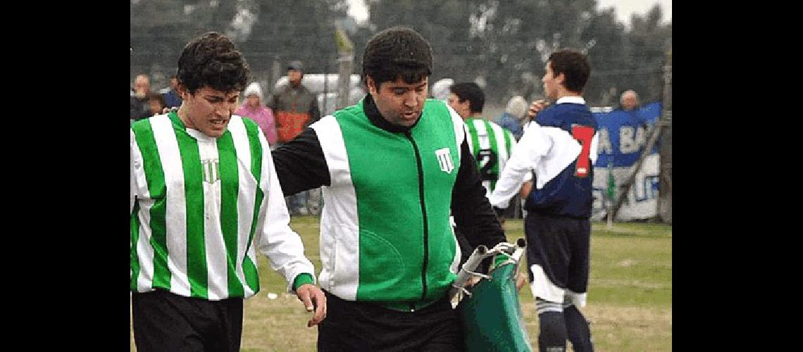 Miguel Diorio (derecha) arquero y dirigente acompaÃ±a a un jugador lesionado Lucas Pagano 