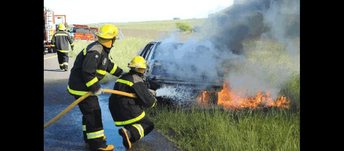 Los bomberos tratando de sofocar el avance de las llamas del vehÃ­culo Agencia 