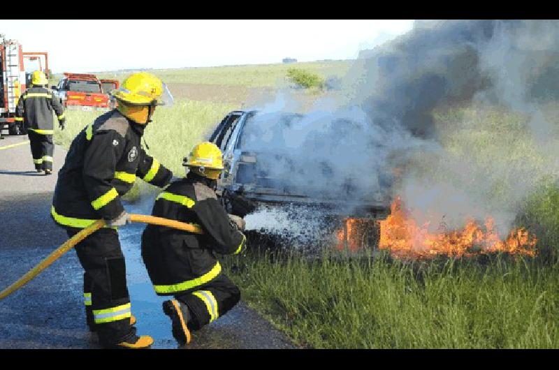 Los bomberos tratando de sofocar el avance de las llamas del vehÃ­culo Agencia 