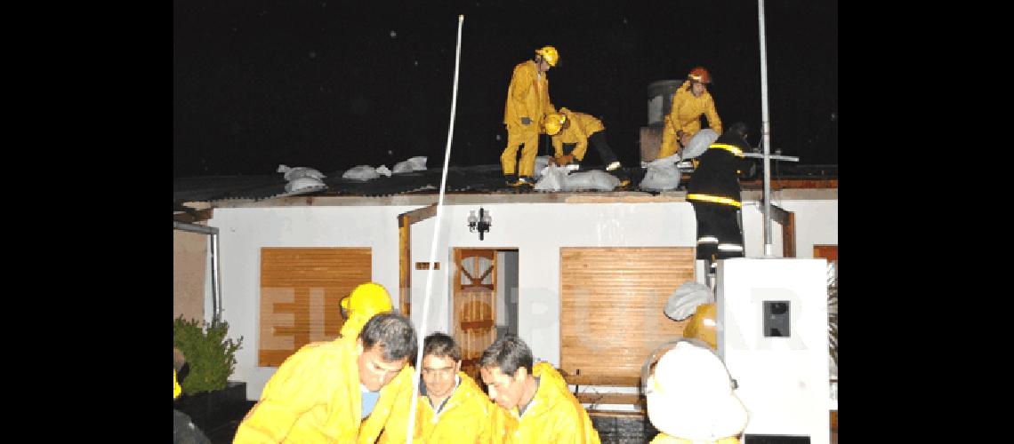 Momento que colocan bolsas de arena sobre las chapas en una viviendas mÃ�s afectadas en Los Robles 