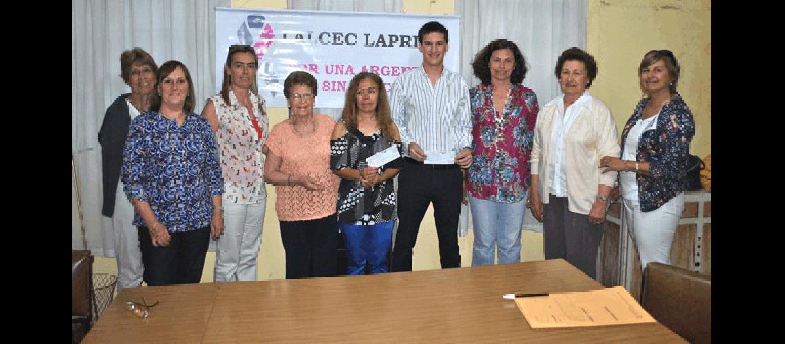 Las integrantes de la Lalcec Laprida junto a los ganadores de la rifa anual 