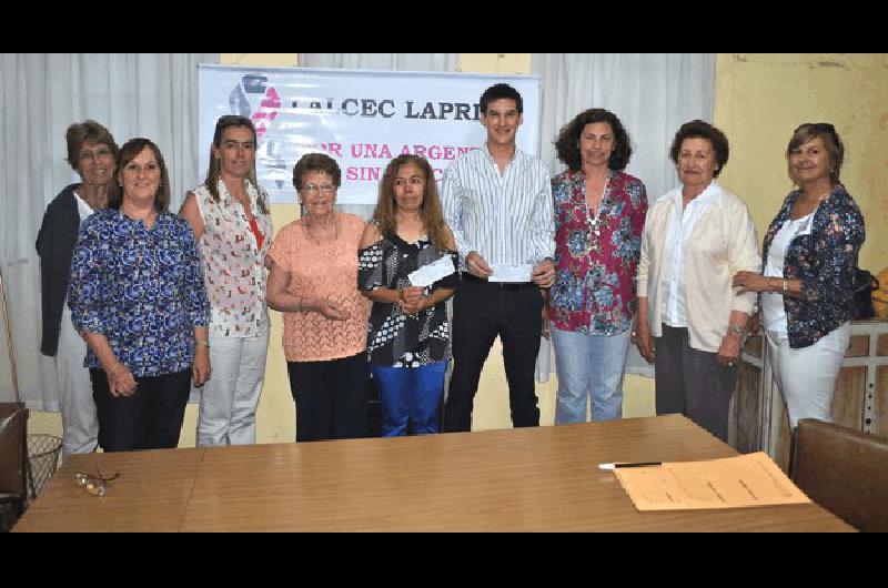 Las integrantes de la Lalcec Laprida junto a los ganadores de la rifa anual 