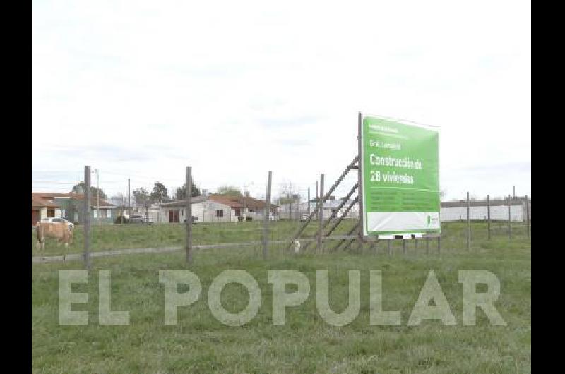 Viviendas ARE Hoy en el obrador del acceso un cartel reza el inicio de la obra y cuatro caballos pastan en el cerco 