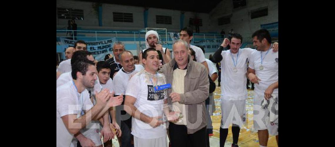 Enrique ElÃ­as Tolcachier le entrega el trofeo al capitÃn del equipo Albinegro el base olavarriense Federico Silveyra 