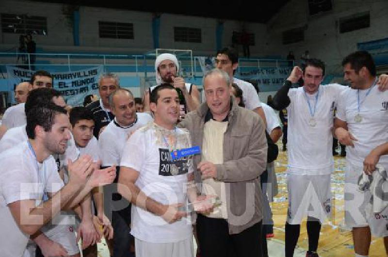 Enrique ElÃ­as Tolcachier le entrega el trofeo al capitÃn del equipo Albinegro el base olavarriense Federico Silveyra 