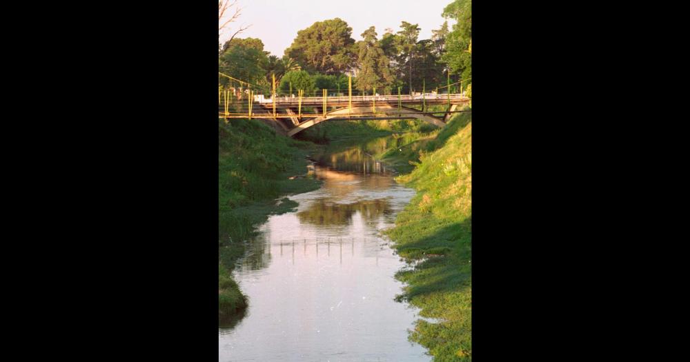 Una vista del arroyo Tapalqué en su tramo de la planta urbana de la ciudad de Olavarría a mediados de la década de 1990 donde se observan el puente colgante de la calle Alvaro Barros y el puente de la avenida Colón